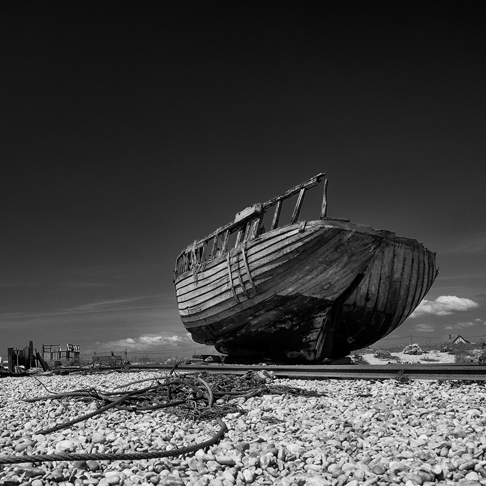 Een achtergelaten vissersboot op het strand van Dungeness, Kent, Verenigd Koninkrijk.